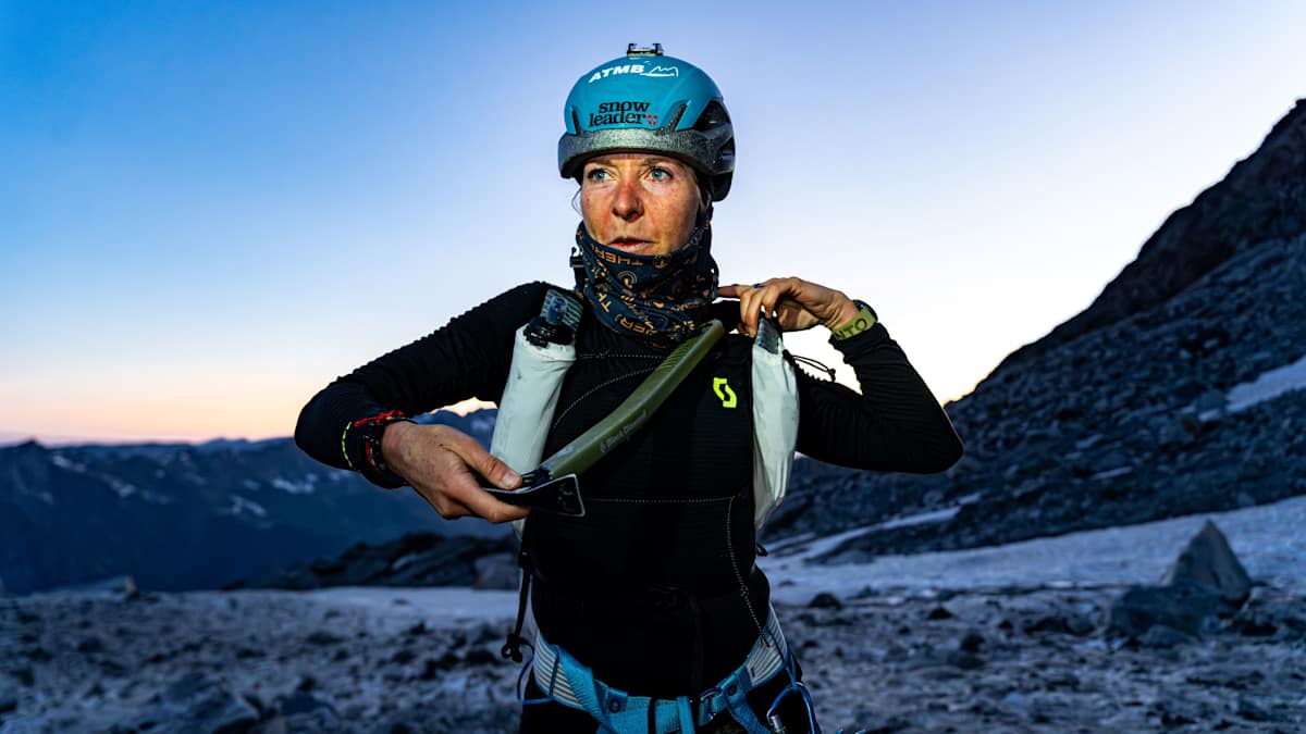 Iris Pessey gearing up on the Mont Blanc glacier at dawn, ice axe in hand and SCOTT vest on