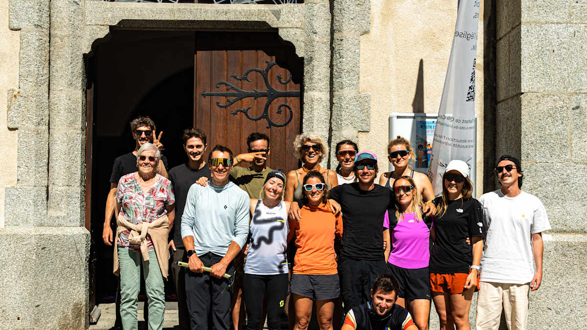 Iris Pessey and the full Mont Blanc Express team celebrating together on the steps of the Chamonix church after the FKT